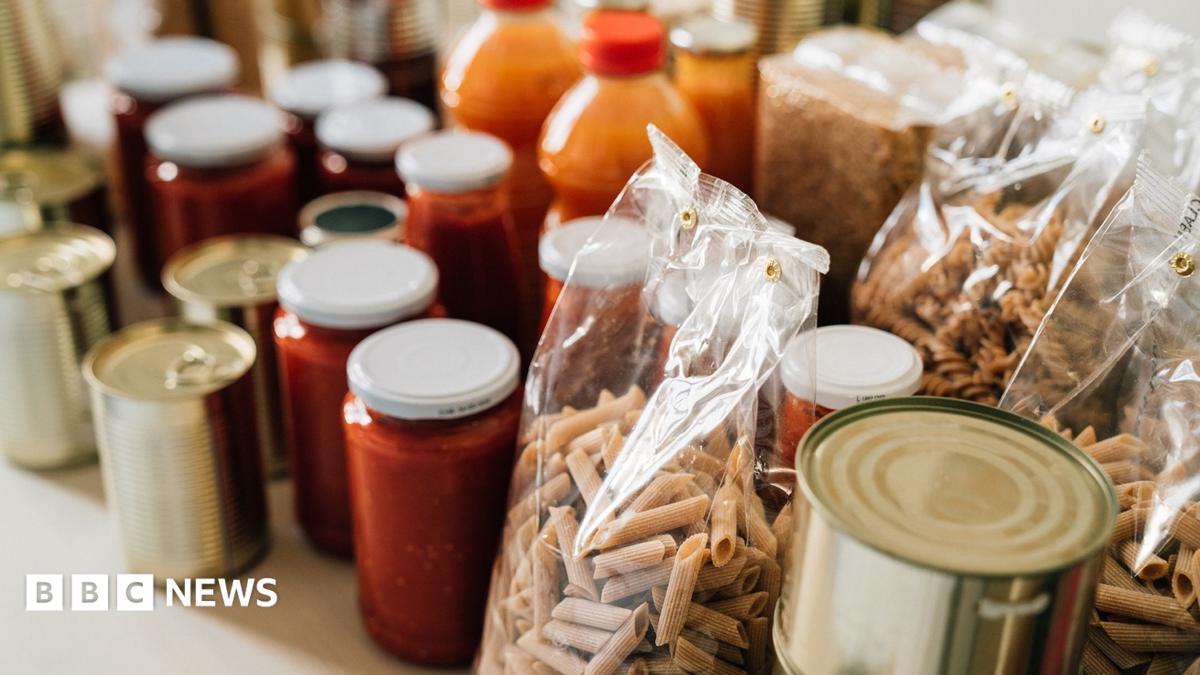 Stock photo shows jarred food and household pantry items stacked on a shelf in close up.