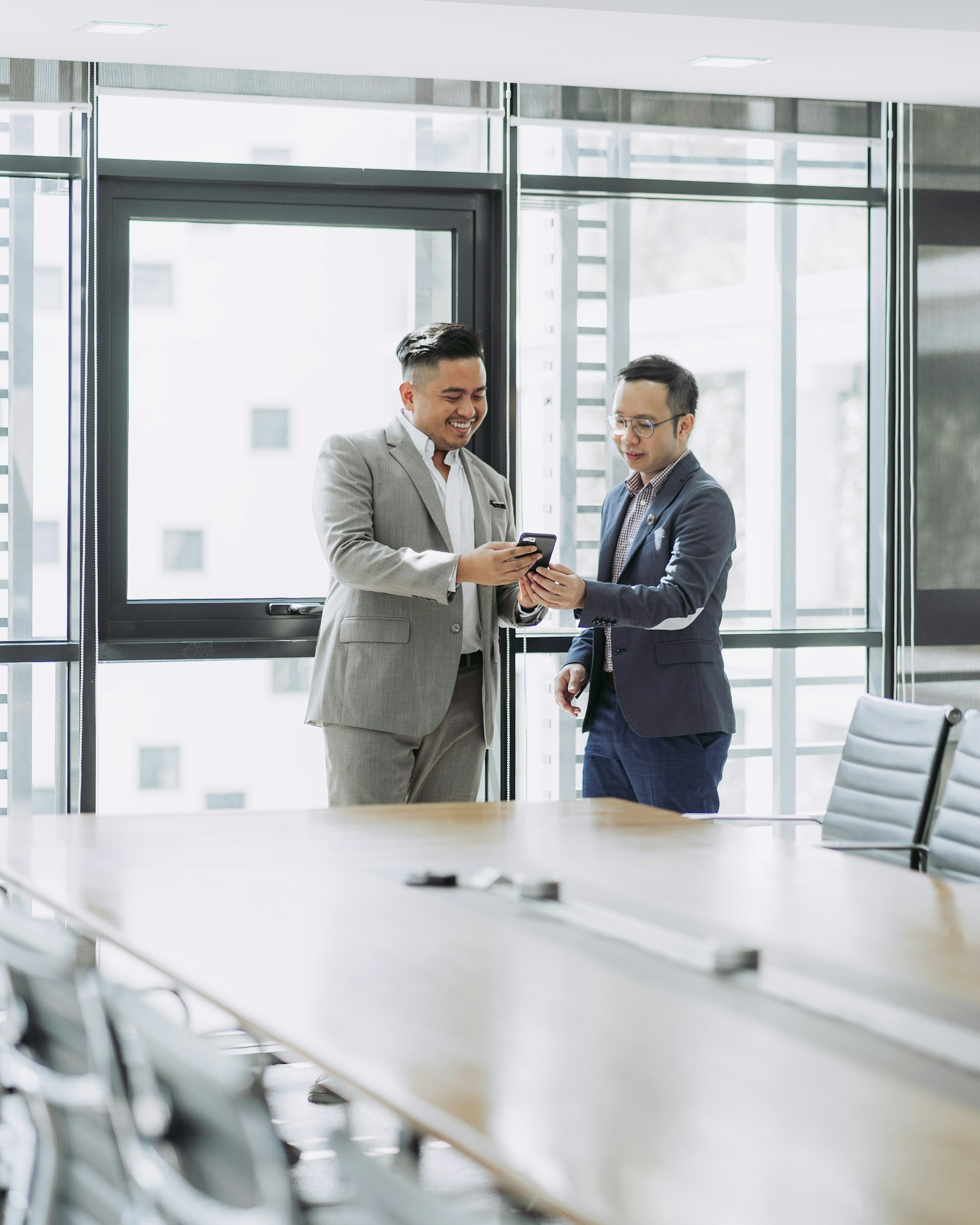 Two business professionals discussing a brief in a bright meeting room
