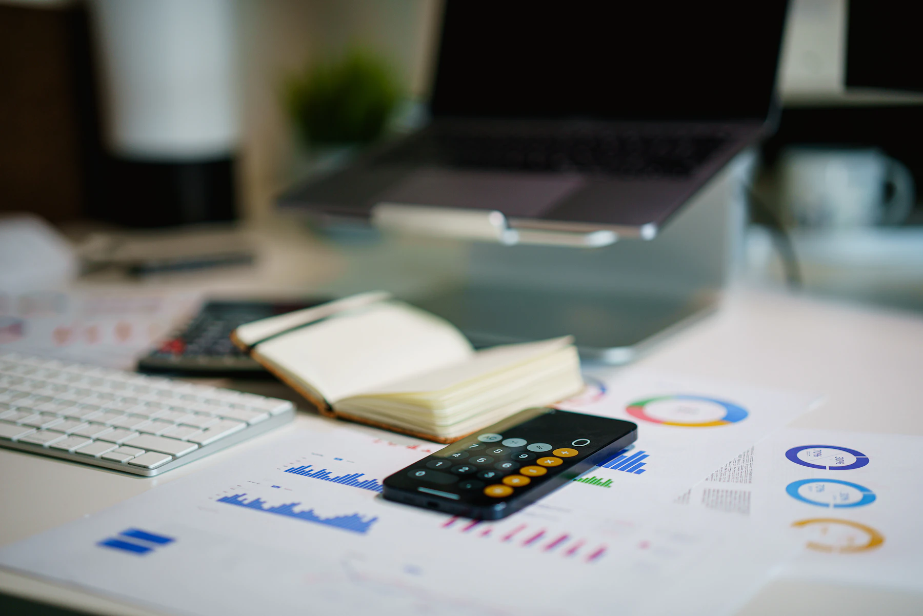 Reports, charts, notes and calculator arranged on an analyst desk